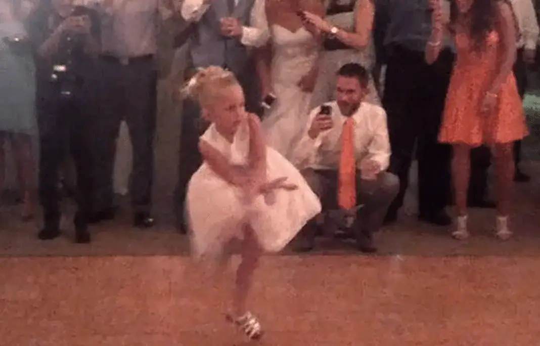 Flower girl having a blast dancing at wedding reception