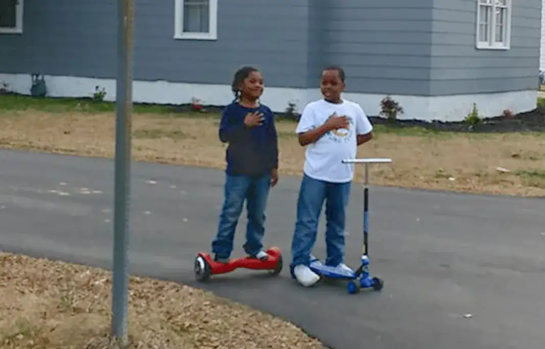 Young boys pause in road to honor raising of US flag – let’s show them love and support