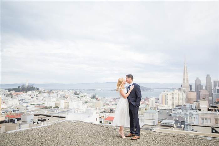Shanna Wagnor and Sean Lewis taking their engagement photos on top of the roof of their apartment building, overlooking San Francisco. Courtesy of Lori Paladino Photography