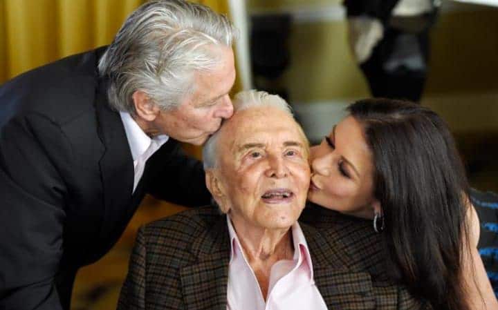 Actor Kirk Douglas gets a kiss from his son Michael Douglas, left, and Michael's wife Catherine Zeta-Jones during his 100th birthday party at the Beverly Hills Hotel CREDIT: CHRIS PIZZELLO/INVISION/AP