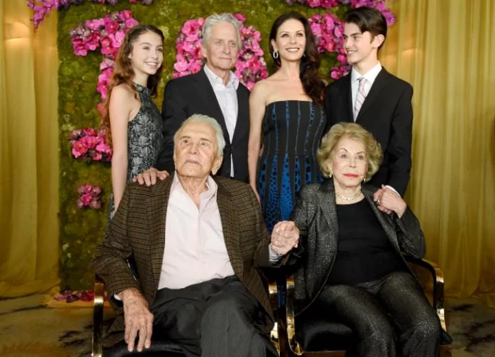 Kirk Douglas, seated left, holds hands with his wife Anne Douglas, seated right, as they pose with family members, their son Michael, standing second left with his wife Catherine Zeta-Jones, and their children, Carys Zeta Jones, left, and son Dylan CREDIT: CHRIS PIZZELLO/INVISION/AP 