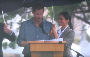 The Duchess of Sussex hold the umbrella for the Duke